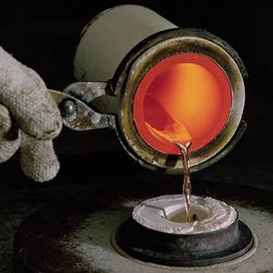 Photo of a person pouring hot metal to cast jewelry